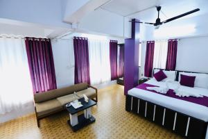 a hotel room with a bed and a couch at Kalpataru Hometel in Mumbai
