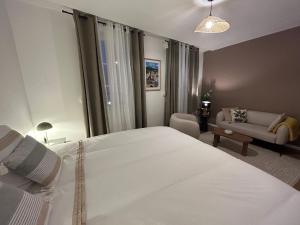 a bedroom with a large white bed and a living room at Downtown High Standing Duplex - "CENTRUM" in Épernay