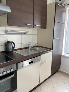 a kitchen with a sink and a stainless steel refrigerator at Apartment Sajković in Ugljan