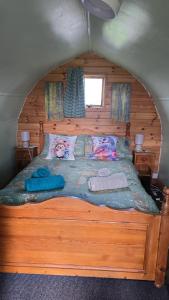 a bedroom with a large wooden bed in a cabin at Cherry Trees Farm Campsite in Welton