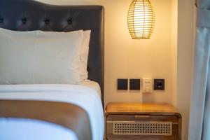 a bed with a black headboard and a wooden night stand at Lala Panzi Villa by Manara in Jimbaran