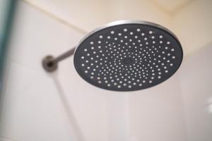 a shower with a black shower head in a bathroom at Lala Panzi Villa by Manara in Jimbaran +17 photos