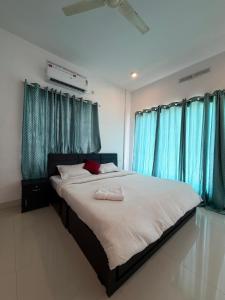 a bedroom with a large bed with blue curtains at Wiztearia in Ambalavayal