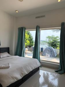 a bedroom with a bed and a large window at Wiztearia in Ambalavayal