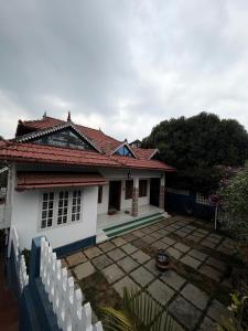 a small white house with a red roof at Wiztearia in Ambalavayal