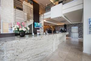 a lobby with a reception counter with flowers at Colosseum Hotel in Cape Town