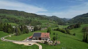 a house with solar panels on top of a green hill at Le Cras in Soubey +5 photos