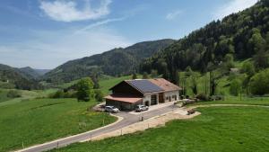 a house with two cars parked in front of a road at Le Cras in Soubey