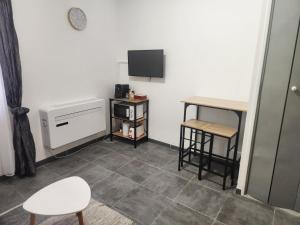 a room with a television and a table and stool at Studio proche de la mer in Calvi