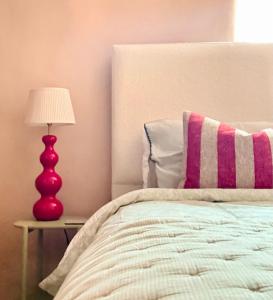 a bedroom with a bed with a red lamp on a table at The Old Feed Store in Okehampton