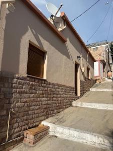 a brick building with stairs and a window on it at Aliki's house in Líthion