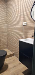 a bathroom with a black toilet and a sink at Casa Caius in Văliug