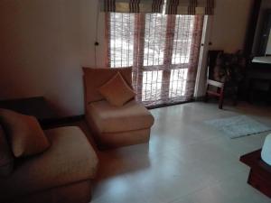 a living room with a couch and a chair at Maple Suite in Kadawata
