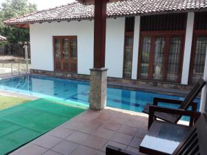 a villa with a swimming pool and a house at Maple Suite in Kadawata