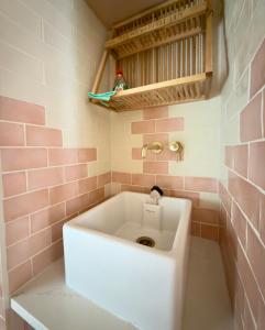 a white sink in a bathroom with pink tiles at The Old Feed Store in Okehampton