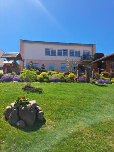 a building with a garden with flowers in a yard at Ferienwohnung Familie Windt in Feldberg +25 photos