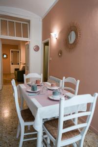 a white dining room table with white chairs and a mirror at L'abbraccio in Dolceacqua +19 photos