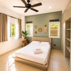 a bedroom with a bed and a ceiling fan at jungle pad accomodation in Rawai Beach