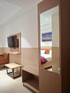 a room with a bedroom with a bed and a mirror at Arunachal residency in Dibrugarh +15 photos