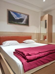 a bedroom with a large bed with a red blanket at Arunachal residency in Dibrugarh