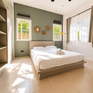 a bedroom with a large bed with two towels on it at jungle pad accomodation in Rawai Beach