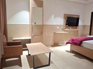 a bedroom with a bed and a table and a chair at Arunachal residency in Dibrugarh