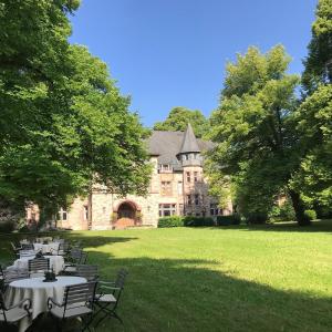 Eine Gruppe von Tischen und Stühlen vor einem Gebäude in der Unterkunft Hotel Hohenhaus in Herleshausen