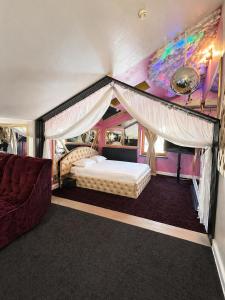 a bedroom with a canopy bed and a couch at Hotel Boutique18plus - Adults Only in Mamaia Sat/Năvodari +115 photos