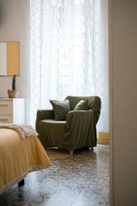 a living room with a green couch in front of a window at L'abbraccio in Dolceacqua
