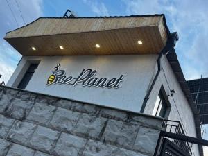 a sign on the side of a building at Bee Planet Garni in Garni