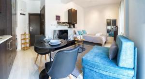 a living room with a blue couch and a table at Elysian Hightower in Thessaloniki +5 photos