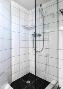 a shower with a glass door in a bathroom at Elysian Hightower in Thessaloniki