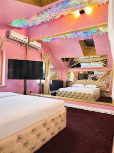 two beds in a room with pink walls at Hotel Boutique18plus - Adults Only in Mamaia Sat/Năvodari