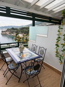 a table and chairs on a balcony with a view of the water at Sofia's Holiday Apartment in Vlorë