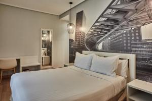 ein Schlafzimmer mit einem großen weißen Bett und einem großen Fenster in der Unterkunft Hotel Silken Sirimiri in Bilbao