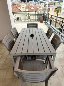 a wooden table and chairs on a balcony at Attico Matteotti Sanremo Luxury Terrace Apartment in Sanremo