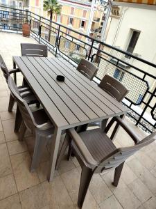 a wooden table and chairs on a balcony at Attico Matteotti Sanremo Luxury Terrace Apartment in Sanremo