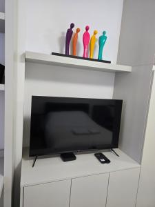 a tv on a white shelf with colorful vases at Brussels square in Brussels