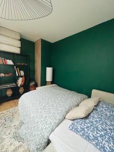 a bedroom with a large bed and a green wall at Downtown High Standing Duplex - "CENTRUM" in Épernay +7 photos