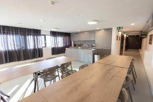 a room with tables and chairs and a kitchen at Vercorin group lodge 18 people in Chalais