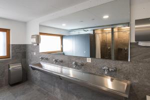 a public bathroom with stainless steel sinks and a mirror at Vercorin group lodge 18 people in Chalais +32 photos