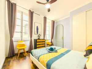 a bedroom with a bed and a yellow chair at Chic Bastide in Carcassonne