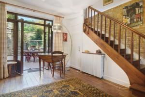 a living room with a staircase and a table at Maison des papillons Daglan in Daglan