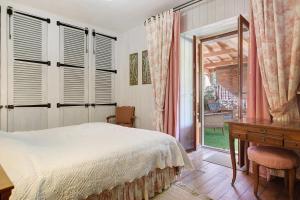 a bedroom with a bed and a desk and a window at Maison des papillons Daglan in Daglan +29 photos