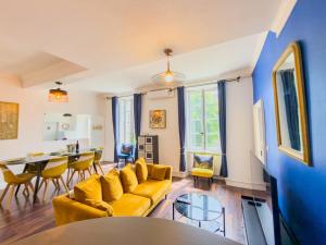 a living room with a yellow couch and a table at Chic Bastide in Carcassonne