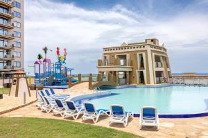 a pool with chairs and a slide at a resort at Tulip Residences Vipingo Mombasa in Mombasa