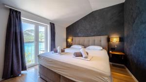 a bedroom with a large bed with a large window at Villa Estera by Villas Guide in Ston