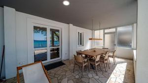 a dining room with a table and chairs and a large window at Villa Estera by Villas Guide in Ston