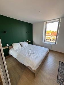 a bedroom with a large bed with a green wall at Gîte des vignobles de Reuilly in Reuilly