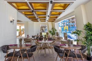 a restaurant with wooden tables and chairs and windows at Tulip Residences Vipingo Mombasa in Mombasa